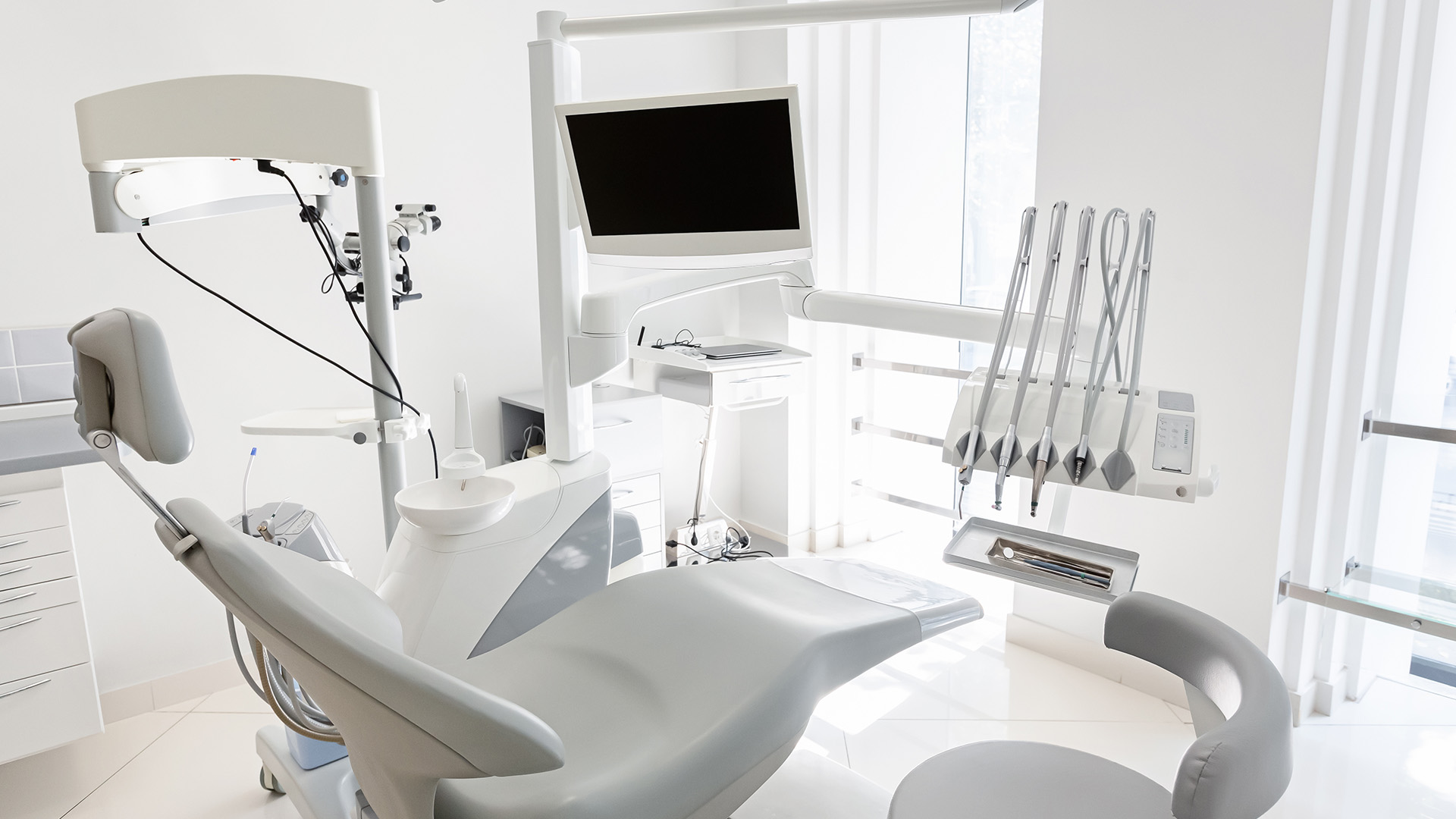 Modern dental office with a large chair, equipment, and a clean, sterile environment.