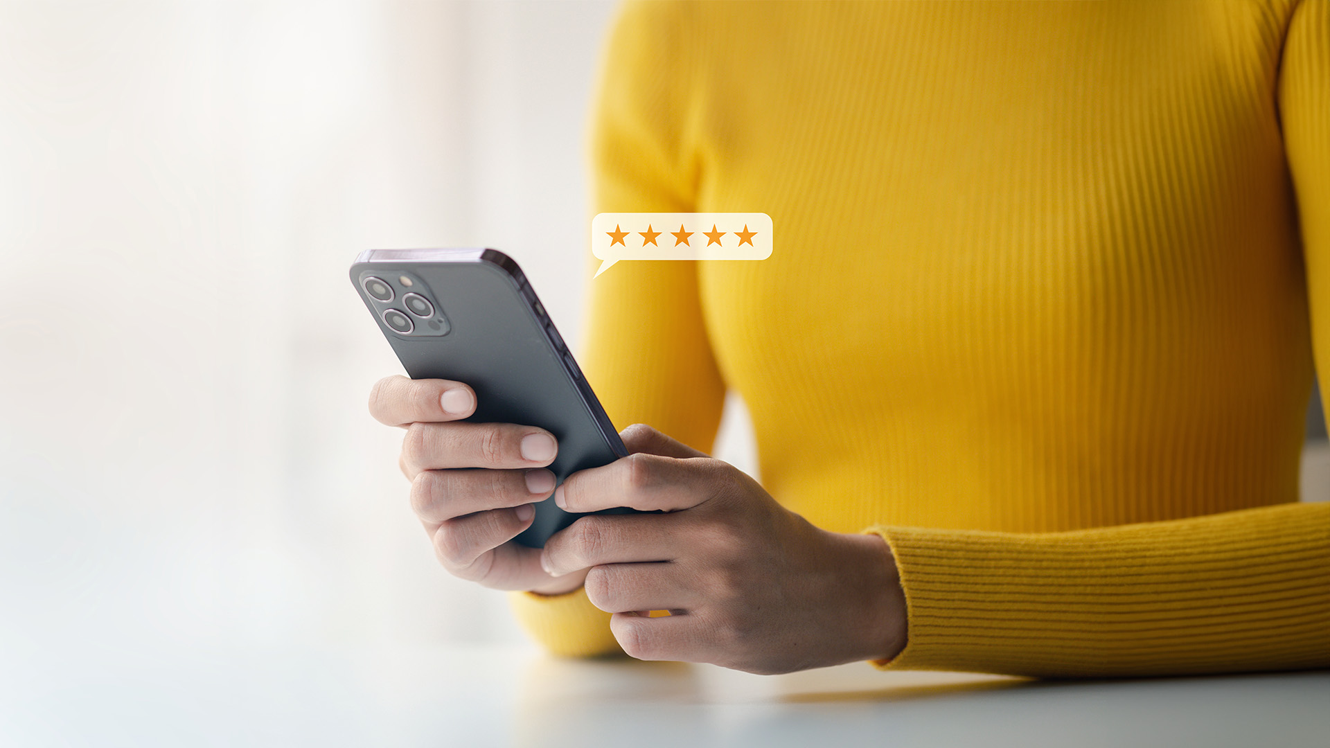 A person holding a smartphone with a yellow tag on it, indicating a rating or review system.