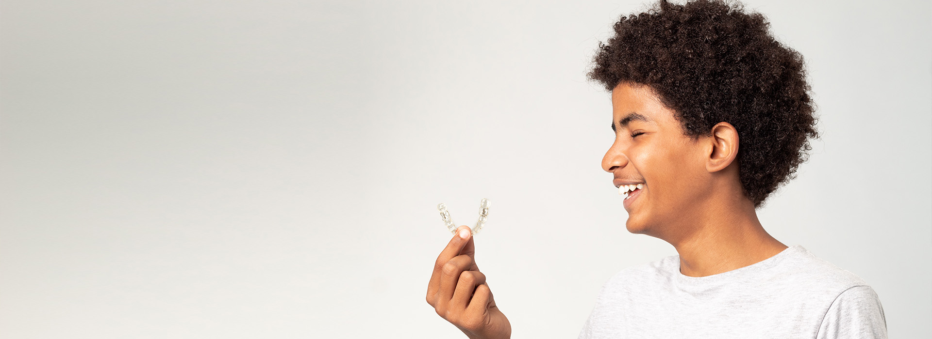 A young person holding a small bird in their hand, smiling at the camera.