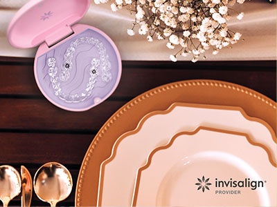 The image displays a collection of dinnerware and a cosmetic case, set against a background that includes a table setting with plates, cutlery, and a decorative item, all arranged on a wooden surface.