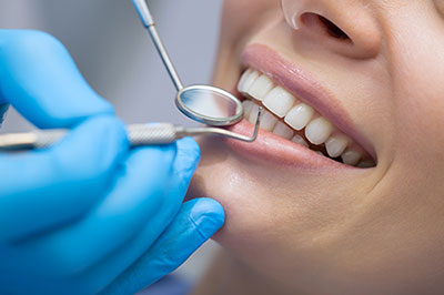 Person receiving dental treatment with a dental hygienist performing the procedure.