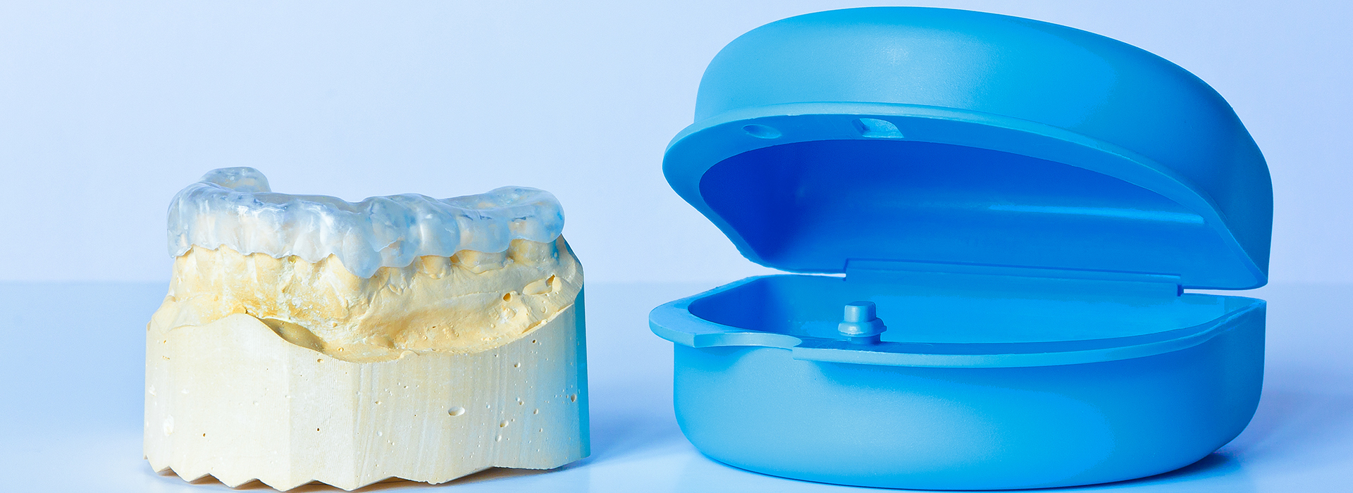 The image displays a dental implant on the left side and a blue, toothbrush-shaped object on the right.