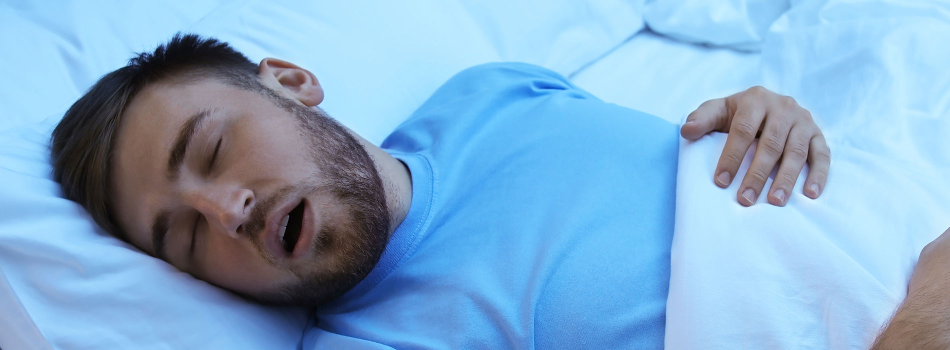 A man in a hospital bed is asleep with his mouth open.